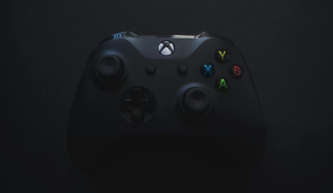 Xbox controller illuminated against a dark background, perfect for gaming themes.