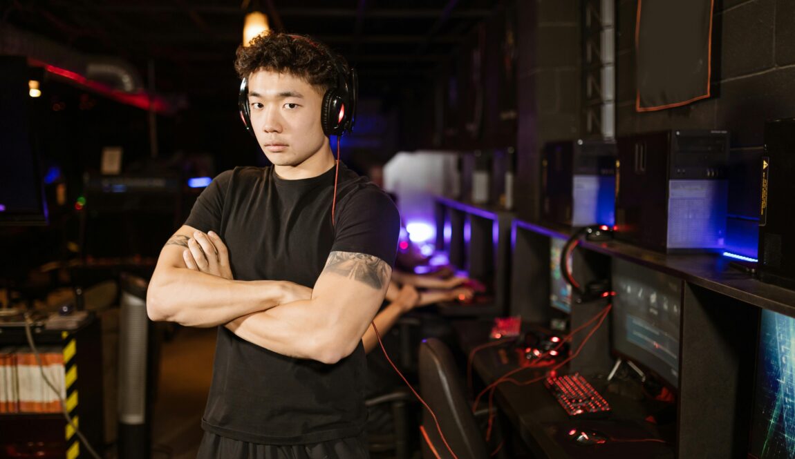 A confident gamer stands in a modern eSports arena, showcasing the gaming environment.